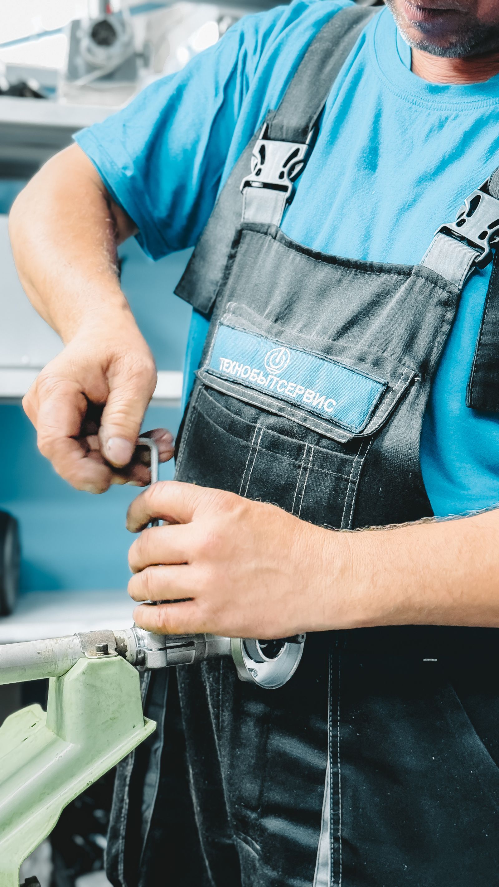 Plumber in blue overalls repairing a pipe