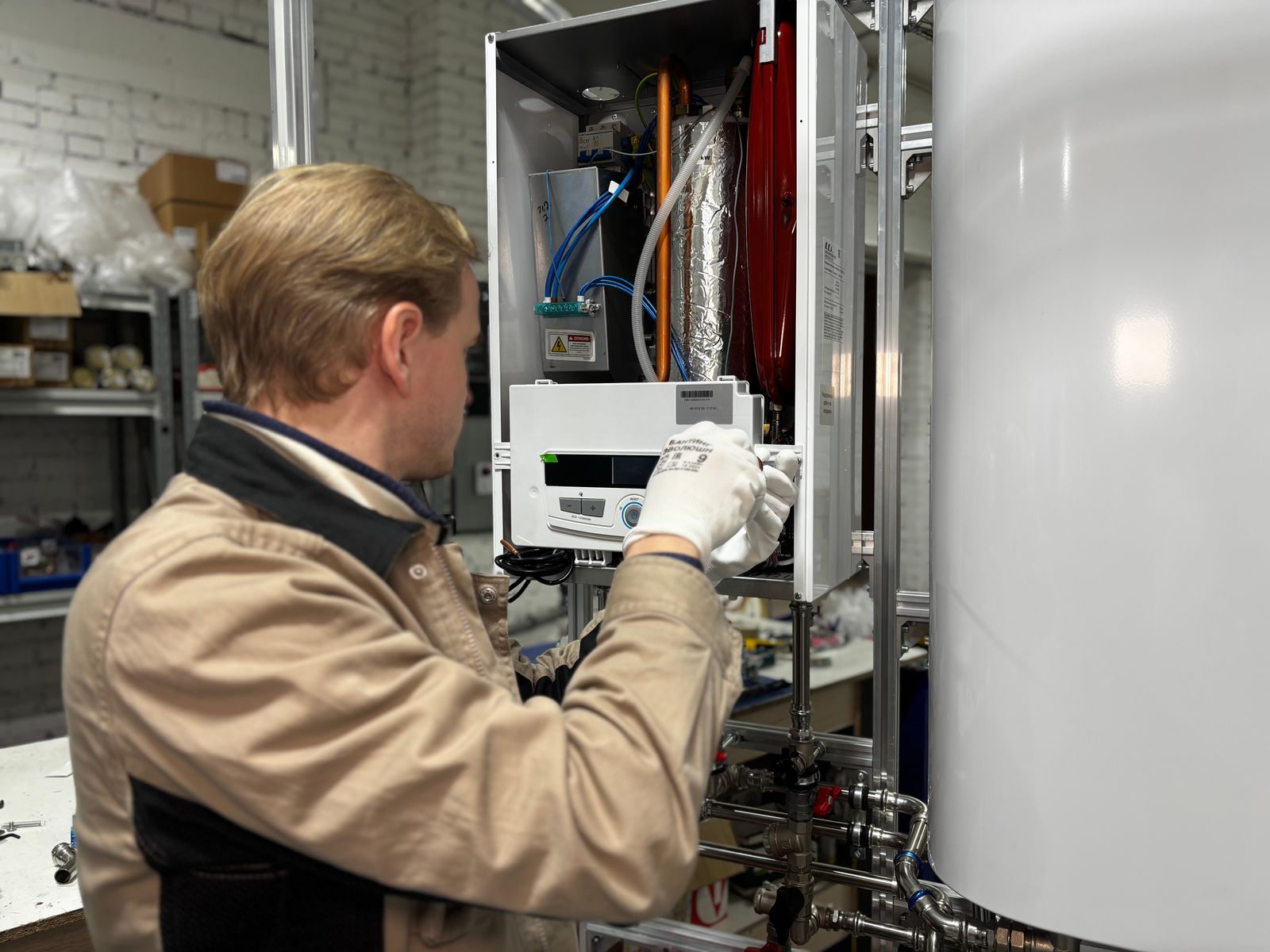 Technician servicing a water heater and its plumbing connections