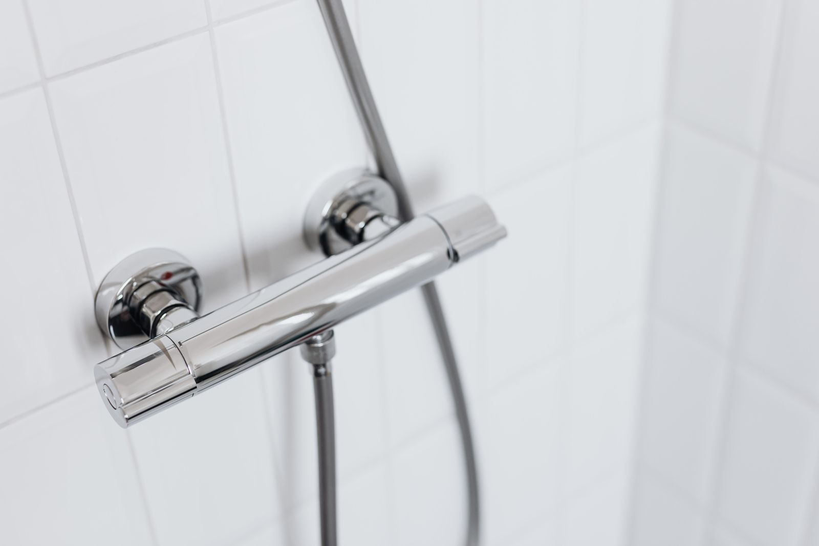 Chrome shower valve on white tile